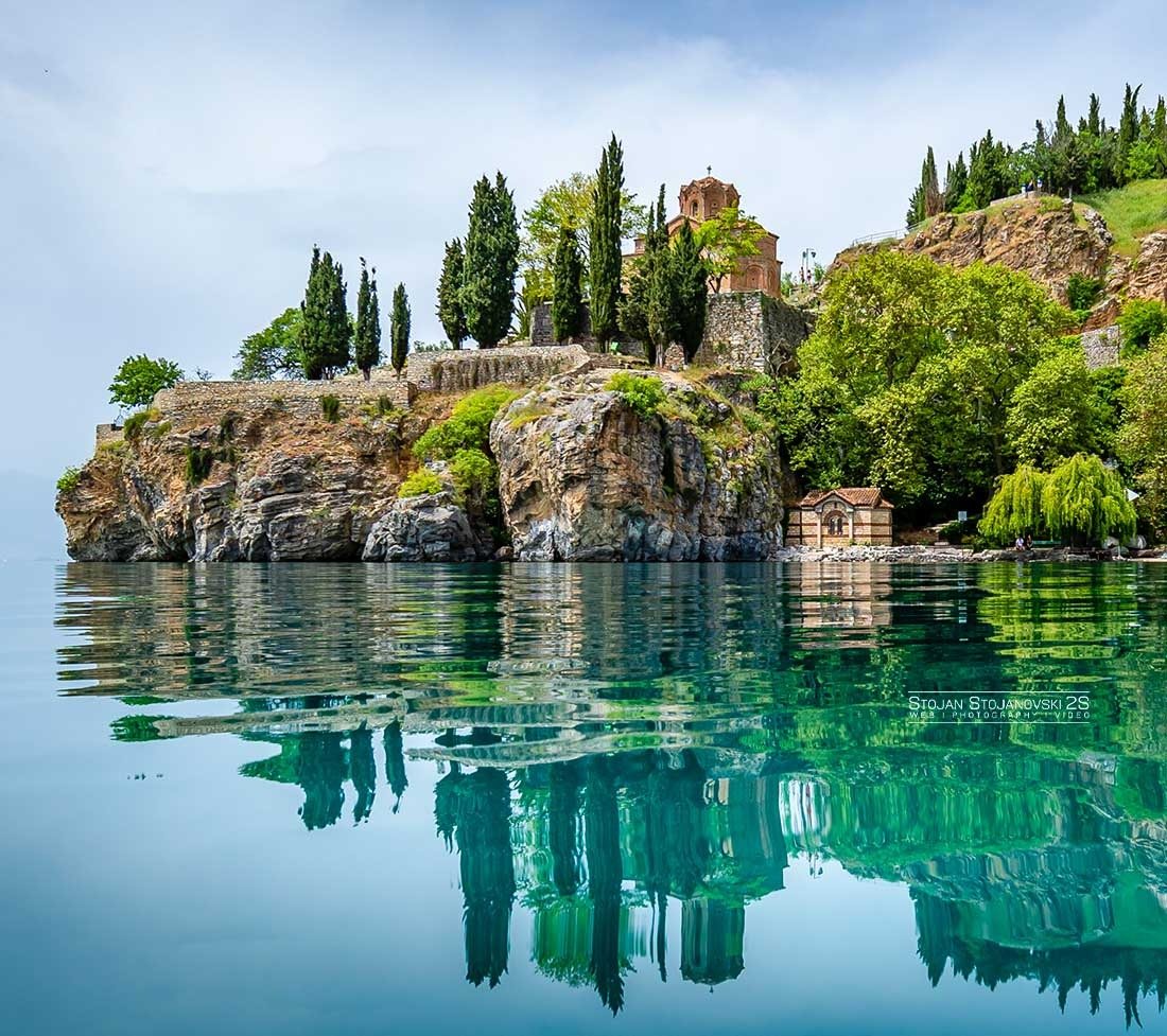 Catamaran on Lake Ohrid passing beneath Kaneo church